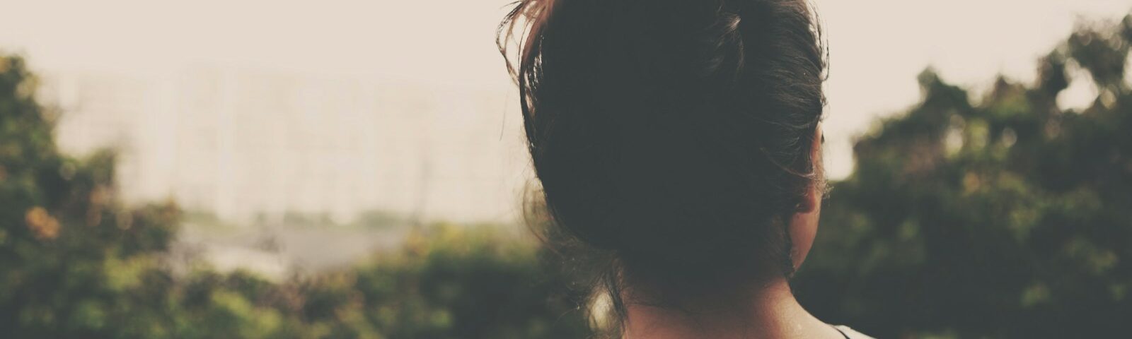 focus photography of woman facing trees