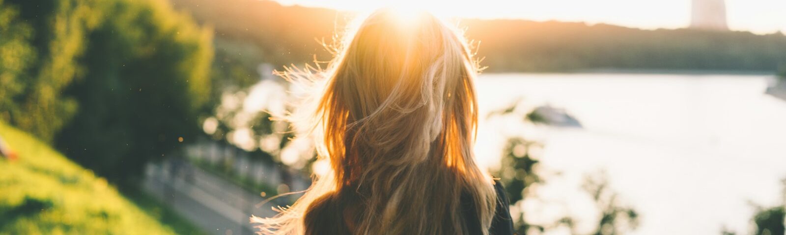 woman sitting while looking at the sunset